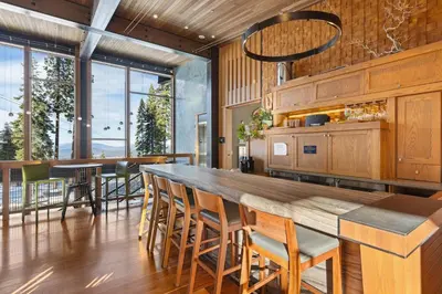 a kitchen with a large wooden bar with chairs at Gondola Getaway- Ski-in Ski-out - Luxury 4 BR, Private Hot Tub, HOA Amenities in Truckee