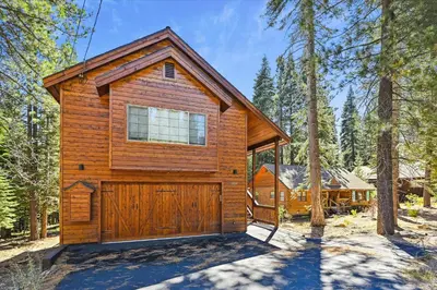 a cabin in the woods with a garage at Graystone Retreat - Modern Retreat w Hot Tub & HOA Amenities in Truckee