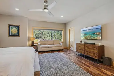 a bedroom with a bed and a couch and a window at Graystone Retreat - Modern Retreat w Hot Tub & HOA Amenities in Truckee