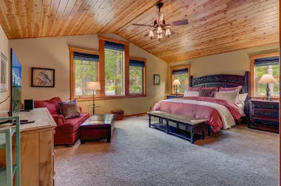 a bedroom with a bed and a couch at High Country Lodge by Tahoe Getaways - Tahoe Donner 4BR w Hot Tub, Air Conditioning, EV, HOA, Shuffleboard and Horse Shoe Pit in Truckee