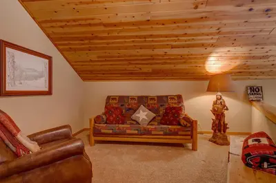 a living room with a couch and a lamp at High Country Lodge by Tahoe Getaways - Tahoe Donner 4BR w Hot Tub, Air Conditioning, EV, HOA, Shuffleboard and Horse Shoe Pit in Truckee