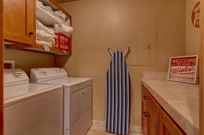 a small laundry room with a washer and dryer at High Country Lodge by Tahoe Getaways - Tahoe Donner 4BR w Hot Tub, Air Conditioning, EV, HOA, Shuffleboard and Horse Shoe Pit in Truckee