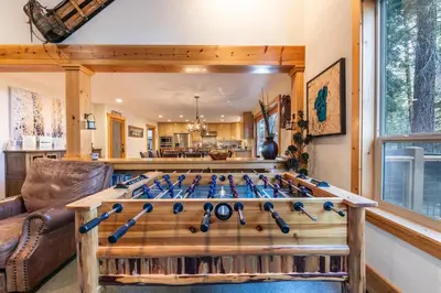 a game room with a wooden table with baseball bats at Indian Hills at Northstar by Tahoe Getaways - Spacious 4 BR, Private Hot Tub, Wood Fireplace, and HOA Amenities in Truckee