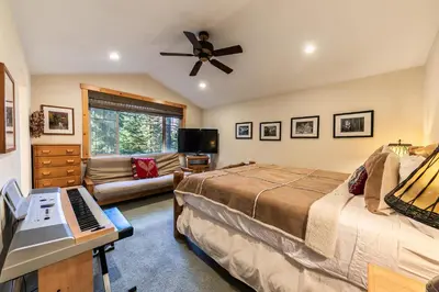 a bedroom with a bed and a desk with a piano at Indian Hills at Northstar by Tahoe Getaways - Spacious 4 BR, Private Hot Tub, Wood Fireplace, and HOA Amenities in Truckee