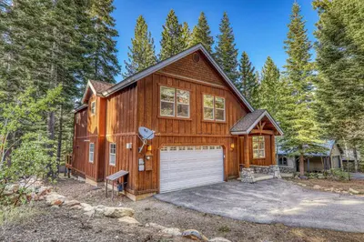 a large wooden house with a garage at Indian Hills at Northstar by Tahoe Getaways - Spacious 4 BR, Private Hot Tub, Wood Fireplace, and HOA Amenities in Truckee