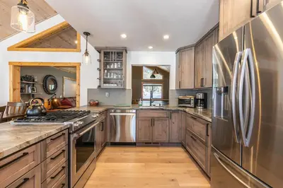 a kitchen with wooden cabinets and stainless steel appliances at Kokanee at Tahoe Donner - Charming 3 BR - Pool Table - Fireplace - Amenity Access! in Truckee