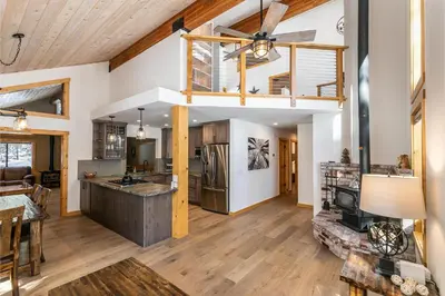 an open kitchen and living room with a ceiling fan at Kokanee at Tahoe Donner - Charming 3 BR - Pool Table - Fireplace - Amenity Access! in Truckee