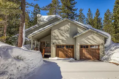a house covered in snow with a pile of snow at Kokanee at Tahoe Donner - Charming 3 BR - Pool Table - Fireplace - Amenity Access! in Truckee