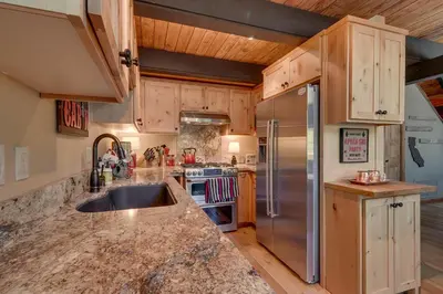 a kitchen with wooden cabinets and a stainless steel refrigerator at Lazy Bear in Tahoe City
