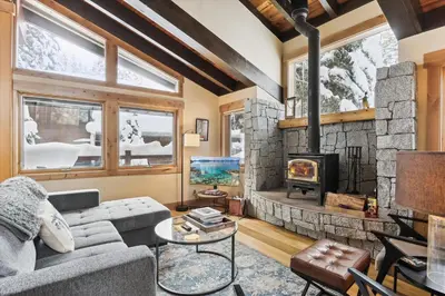 a living room with a couch and a fireplace at Mariposa Heights at Alpine - Ski Shuttle to Slopes- Fireplace- Forest Views in Alpine Meadows
