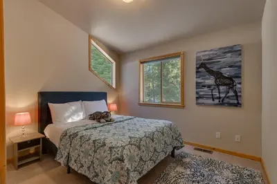 a bedroom with a bed with a giraffe picture on the wall at Matterhorn at Tahoe Donner 3000 Sqft 4 BR with Private Hot Tub and HOA Pool, Gym and Beach Access in Truckee