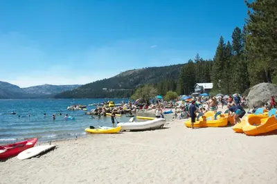 a crowd of people on a beach with boats at Matterhorn at Tahoe Donner 3000 Sqft 4 BR with Private Hot Tub and HOA Pool, Gym and Beach Access in Truckee