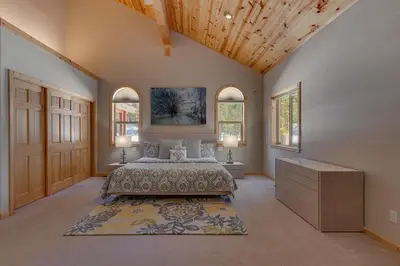 a large bedroom with a bed and two windows at Matterhorn at Tahoe Donner 3000 Sqft 4 BR with Private Hot Tub and HOA Pool, Gym and Beach Access in Truckee