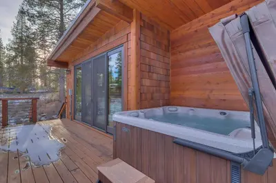 a wooden cabin with a hot tub on a deck at Meek Court at Grays Crossing - Modern Luxury with Private Hot Tub in Truckee