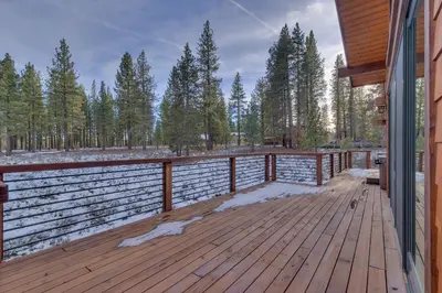 a wooden deck with snow on the ground at Meek Court at Grays Crossing - Modern Luxury with Private Hot Tub in Truckee