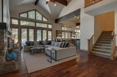 a large living room with a couch and a staircase at Mountain Majesty at Grays Crossing - Luxury 4BR 4BA w Private Hot Tub in Truckee
