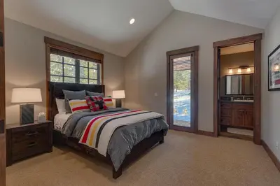 a bedroom with a large bed and a bathroom at Mountain Majesty at Grays Crossing - Luxury 4BR 4BA w Private Hot Tub in Truckee