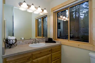 a bathroom with a sink and a large mirror at Olive Branch - Private Hot Tub, Media Room, Pet-Friendly, Near Northstar! in Carnelian Bay