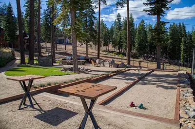 a picnic table in a park with people sitting on the ground at Mountainside by Tahoe Getaways - Luxury Pet-Friendly Northstar Ski-in Ski-Out - Swimming Pool and Gym! in Truckee