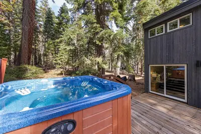 a large hot tub on a deck next to a house at Ellis Peak Retreat - Hot Tub, Wood Fireplace, Close to Tahoe City & Dining in Tahoe City