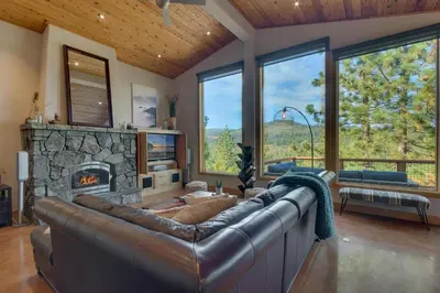 a living room with a leather couch and a fireplace at Pinnacle Views at Tahoe Donner - 4BR, Hot Tub in Truckee