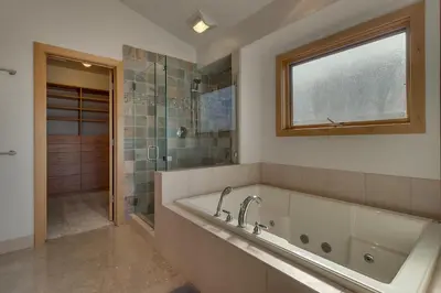 a bathroom with a tub and a shower and a window at Pinnacle Views at Tahoe Donner - 4BR, Hot Tub in Truckee