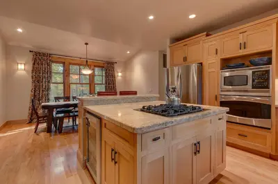 a kitchen with wooden cabinets and a stove top oven at Pine Meadow at Gray's Crossing - 4BR w Two Master Suites in Truckee