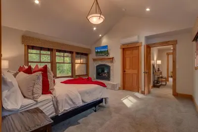 a bedroom with a large bed and a fireplace at Pine Meadow at Gray's Crossing - 4BR w Two Master Suites in Truckee
