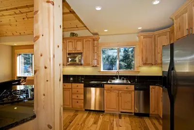 a kitchen with wooden cabinets and stainless steel appliances at Red Cedar on North Shore - Beautiful 3BR w Gorgeous Furnishings in Tahoe City in Tahoe City