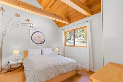 a bedroom with a bed and a window at Wildwood - Modern 2 BR with Private Hot tub Walk to North Tahoe Regional Park in Tahoe Vista