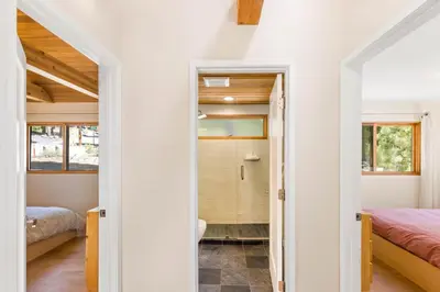 a room with two beds and a walk in shower at Wildwood - Modern 2 BR with Private Hot tub Walk to North Tahoe Regional Park in Tahoe Vista