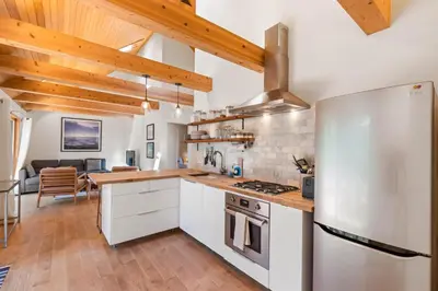 a kitchen with white cabinets and a stainless steel refrigerator at Wildwood - Modern 2 BR with Private Hot tub Walk to North Tahoe Regional Park in Tahoe Vista
