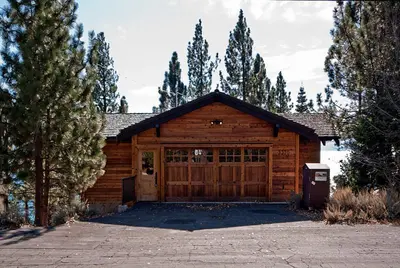 a log cabin with a large wooden garage at Water's Edge Lakefront- Buoy, Private Pier in Tahoe City