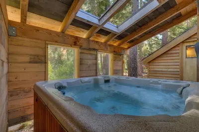 a jacuzzi tub in a log cabin at West Pine Cabin on the West Shore by Tahoe Getaways - 2 BR w 2 Bonus Rooms, Hot Tub, Pool Table & Pet Friendly in Tahoe City