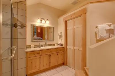 a bathroom with a sink and a mirror and a shower at West Pine Cabin on the West Shore by Tahoe Getaways - 2 BR w 2 Bonus Rooms, Hot Tub, Pool Table & Pet Friendly in Tahoe City