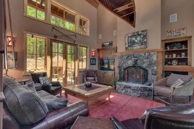a living room with leather furniture and a stone fireplace at New Listing! West Shore Bliss - 4BR, Private Hot Tub in Tahoe City
