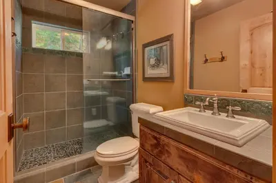 a bathroom with a shower and a toilet and a sink at New Listing! West Shore Bliss - 4BR, Private Hot Tub in Tahoe City
