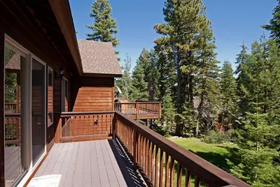 a porch of a house with a deck with trees at Woodside Lodge on West Shore with Private Hot Tub, Pool Table & Game Room in Tahoma