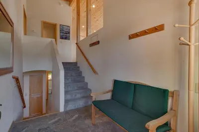 a living room with a green couch and stairs at Stockholm - Beautiful Views in Tahoe Donner - Private Hot Tub - Pet Friendly in Truckee
