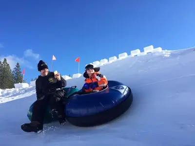 two people riding on a tube in the snow at Stockholm - Beautiful Views in Tahoe Donner - Private Hot Tub - Pet Friendly in Truckee
