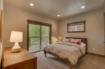 a bedroom with a bed and a lamp and a window at Sunrise Abode at Tahoe Donner - Luxurious New Build, Soaking Tub, HOA Amenities in Truckee