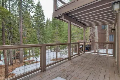 a large deck with a view of the woods at Sunrise Abode at Tahoe Donner - Luxurious New Build, Soaking Tub, HOA Amenities in Truckee