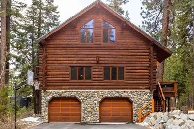 a log cabin with two garage doors at Tahoe Wanderer - 3 BR Luxury Log Cabin with Additional Loft, Private Hot Tub in Tahoe Vista