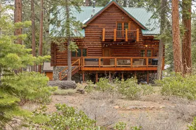 a log cabin in the woods with a deck at Tahoe Wanderer - 3 BR Luxury Log Cabin with Additional Loft, Private Hot Tub in Tahoe Vista