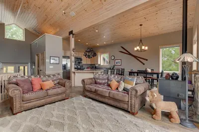 a living room with two couches and a kitchen at Treetop at Tahoe Donner - Pet Friendly 4BR w Gym and Pool Access in Truckee