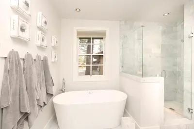a white bathroom with a tub and a toilet at First Light Farmhouse- Hot Tub- Gourmet Kitchen- Premier Neighborhood in Truckee