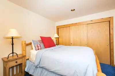 a bedroom with a bed and a wooden door at Victory Place at Palisades - Stunning 5 BR with Private Hot Tub and Pool Table in Olympic Valley