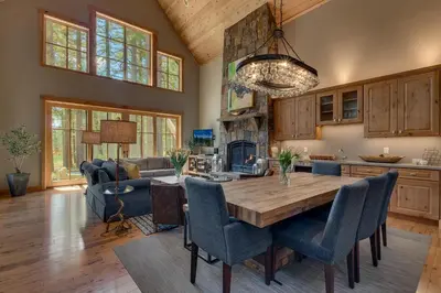 a kitchen and living room with a wooden table and chairs at Truckee Treasure at Grays Crossing by Tahoe Getaways - Relaxing Home w Private Hot Tub, Dogs Welcome! in Truckee