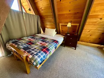 a bedroom with a bed in a wooden cabin at Snowy Paws - Pet Friendly - Alpine Meadows - Amazing views, close to slopes in Olympic Valley