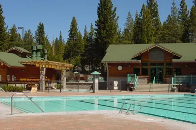 a large swimming pool in front of a lodge at St Bernard at Tahoe Donner Remodeled 3BR - Private Hot Tub and Gym and Pool Access in Truckee